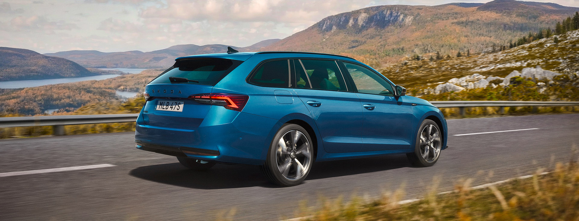 En blå Skoda Octavia Combi kör genom kustlandskap