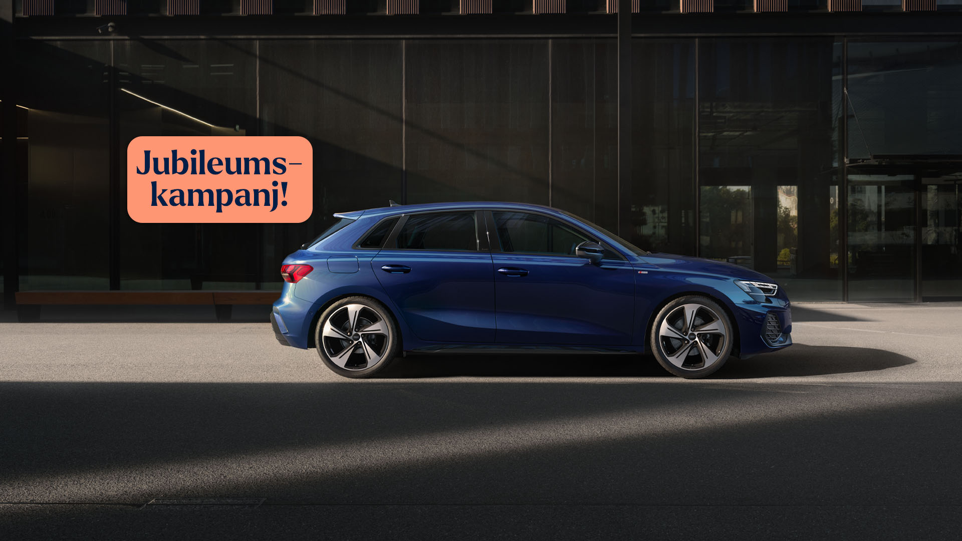 Nya Audi A3 i mörkblå färg, framför husfasad.