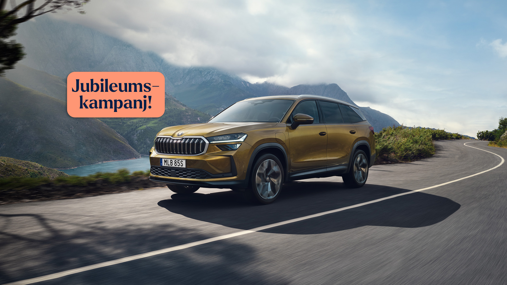 Skoda Kodiaq sedd snett framifrån kommer körande längs solig landsväg